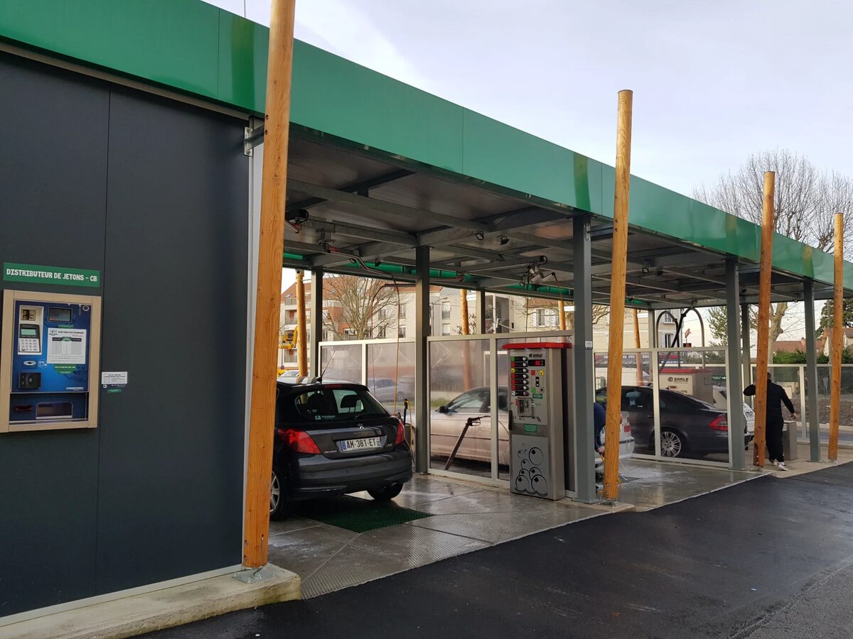 Pistes de lavage haute pression en activité avec distributeur jetons - Installation Expertise Lavage Auto